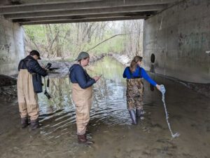 Three volunteers collecting water samples in the ADW.